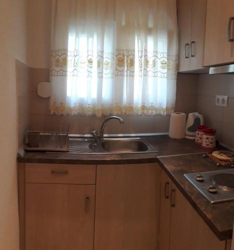 eine Küchentheke mit Spüle und Fenster in der Unterkunft Elena Rooms-Apartments in Asprovalta