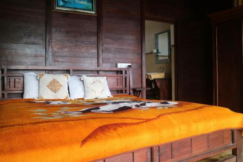 a bedroom with a large bed with an orange blanket at Batur Green Lakeview in Kintamani Bali in Kintamani