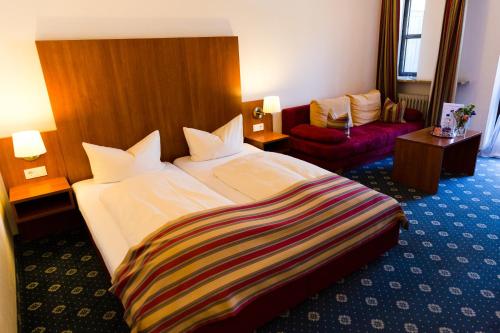 a hotel room with a large bed and a couch at Gästehaus Rössler in Brannenburg