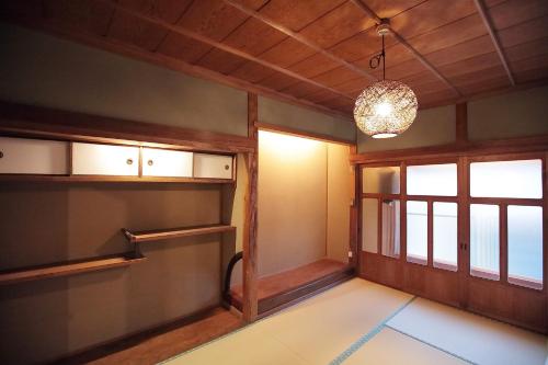 an empty room with a window and a chandelier at HOJO MACHI HOSTEL in Kasai