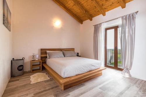 ein Schlafzimmer mit einem Bett und einem großen Fenster in der Unterkunft Villa Luka in Brtonigla