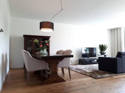 a living room with a table and chairs and a tv at In the old City Centre of Edam, unique apartment. in Edam