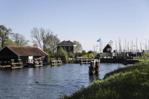 a marina with houses and boats in the water at In the old City Centre of Edam, unique apartment. in Edam