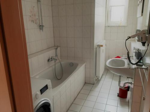 ein weißes Badezimmer mit einer Badewanne und einem Waschbecken in der Unterkunft Hotel Fabrice in Bad Klosterlausnitz