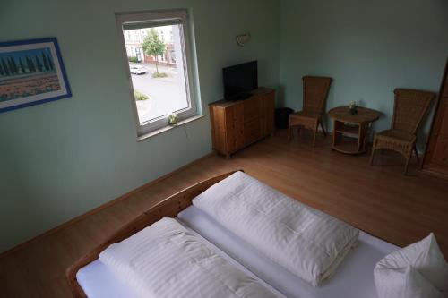 a living room with a bed and a window at Hotel am Bahnhof in Waren