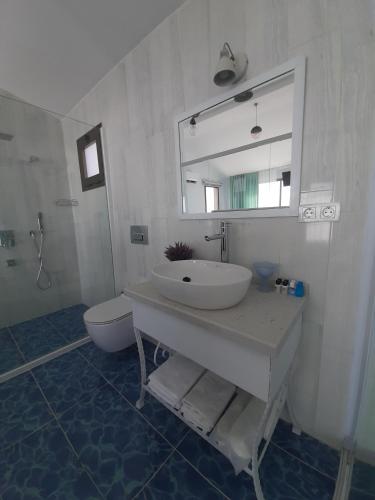 a bathroom with a sink and a toilet and a mirror at Fener Hotel Café & Kahvalti in Cesme