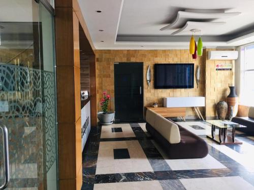 uma sala de estar com um sofá e uma televisão em Restinn Hotel em Maulvi Bāzār