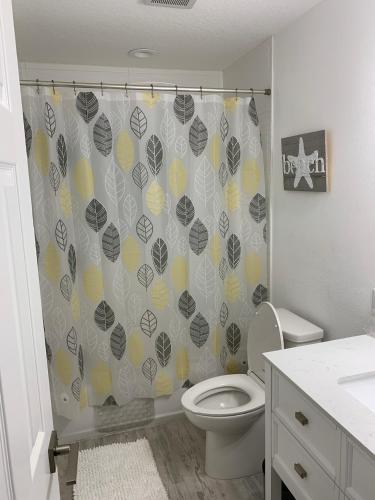 a bathroom with a toilet and a shower curtain at Near Beaches & IMG Academy, Mins to Downtown in Bradenton