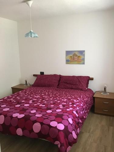 a bedroom with a purple bedspread with pink hearts at Appartamenti Morini in Folgaria