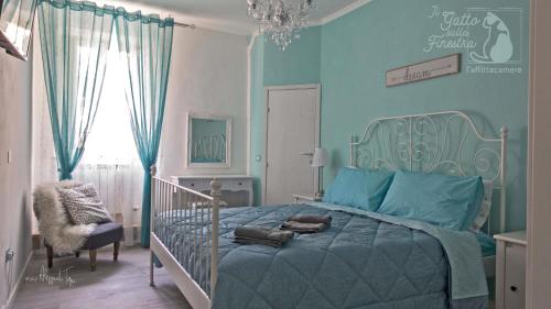 a bedroom with a bed and a blue wall at Il Gatto Sulla Finestra in Iesi
