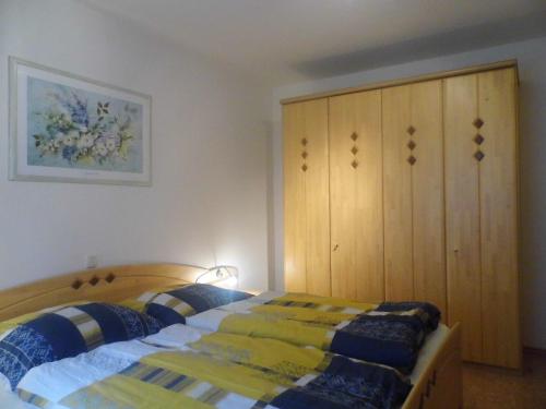 una camera da letto con un letto e un armadio in legno di Ferienwohnung Viehhauser a Hüttschlag