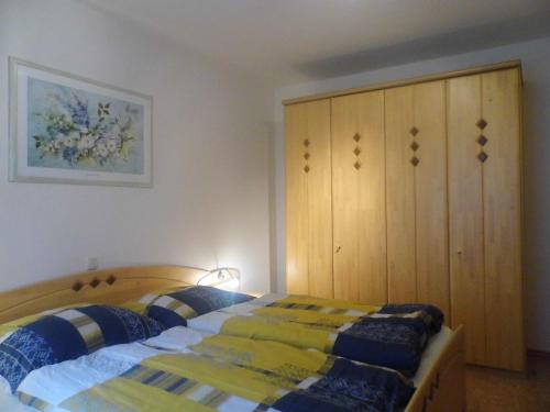 a bedroom with a bed and a wooden cabinet at Ferienwohnung Viehhauser in Hüttschlag