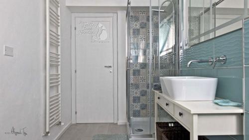 a bathroom with a sink and a glass shower at Il Gatto Sulla Finestra in Iesi