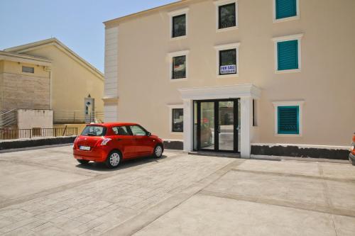 a small red car parked in front of a building at Apartment FUNNY in Kotor