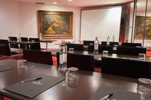 a conference room with tables and chairs and a screen at Hotel Villa Emilia in Barcelona