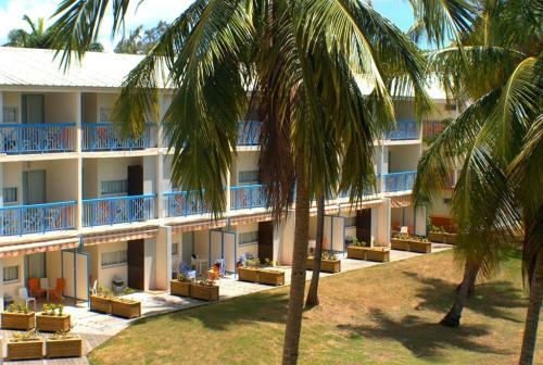 a hotel with palm trees in front of it at CoCoKreyol - Ti CARAYOU in Les Trois-Îlets