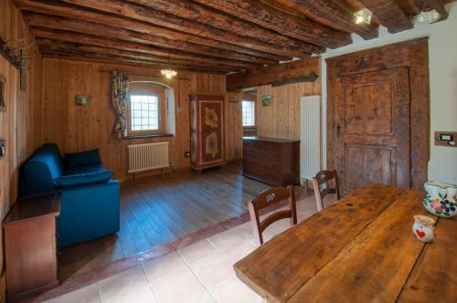 a living room with a wooden table and a blue couch at La Cascina d'Orleans in Saint-Pierre