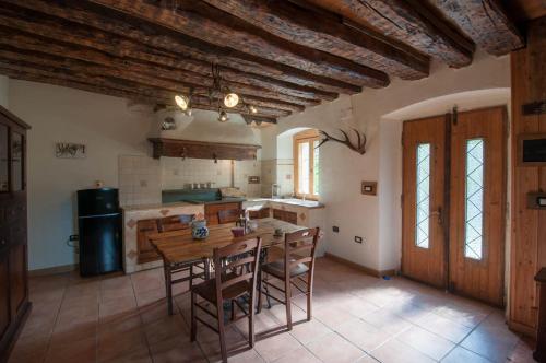 a large kitchen with a wooden table and chairs at La Cascina d'Orleans in Saint-Pierre
