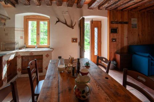 a dining room with a wooden table in a house at La Cascina d'Orleans in Saint-Pierre