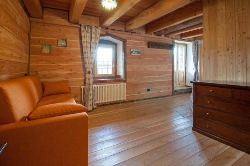 a living room with a couch and wooden walls at La Cascina d'Orleans in Saint-Pierre