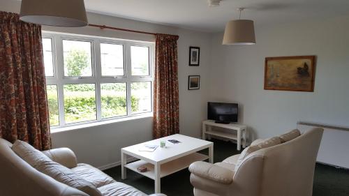 a living room with a couch and a table and a window at The Apartment Bushmills in Bushmills