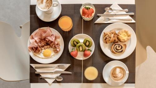 een tafel met borden eten en kopjes koffie bij Hotel La Fortezza in Florence