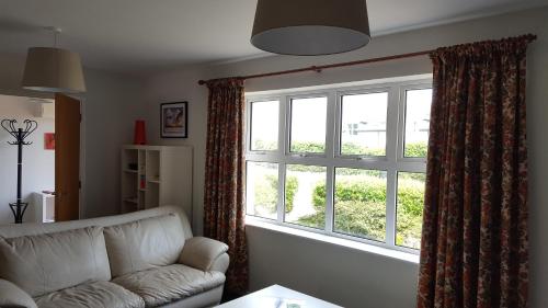 a living room with a couch and a large window at The Apartment Bushmills in Bushmills