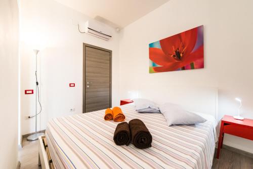 a bedroom with a bed with two pairs of shoes on it at Geco's Apartment in Elmas