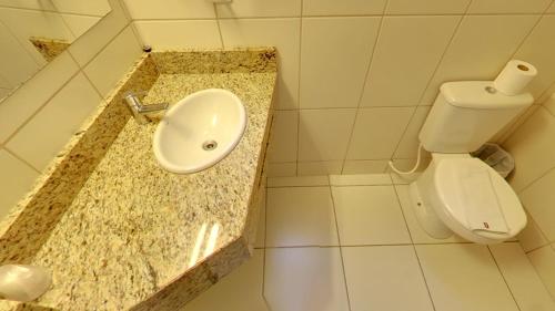 ein Bad mit einem Waschbecken und einem WC in der Unterkunft Hotel Urupes in São Bento do Sul