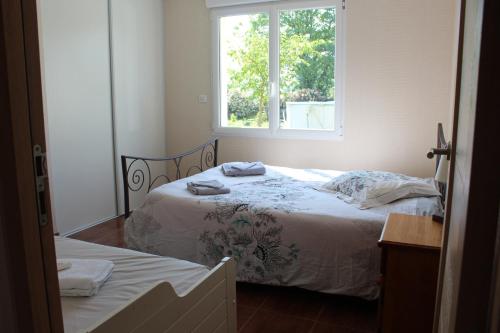 een slaapkamer met een bed en een raam bij B&B La Lyre in Saint-Georges-du-Bois