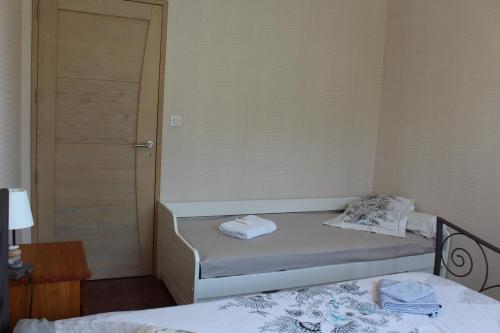 a small bedroom with two beds and a door at B&B La Lyre in Saint-Georges-du-Bois