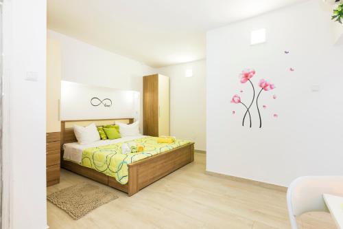 a bedroom with a bed with flowers on the wall at Apartments and rooms Roberto B. in Valun