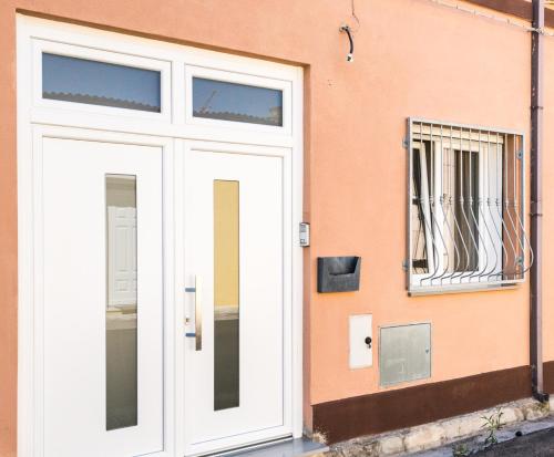 a white door on the side of a building at Geco's Apartment in Elmas