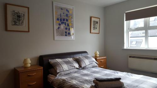 a bedroom with a bed and a window at The Apartment Bushmills in Bushmills