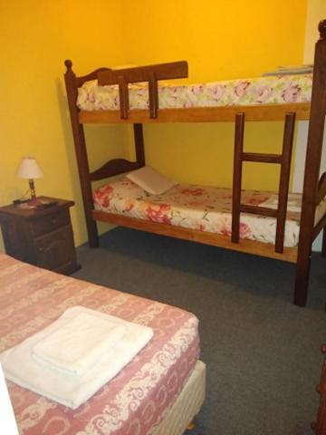 a room with two bunk beds and a table with a lamp at MAU-MAR in Colón