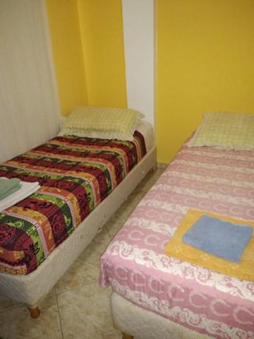 two beds in a room with yellow walls at MAU-MAR in Colón