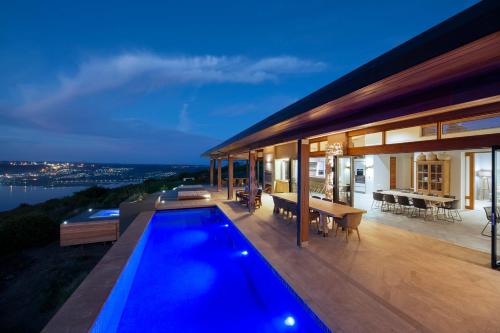 a house with a swimming pool on a deck at night at Alkira Lodge in Brenton-on-Sea