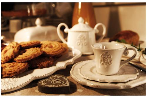 a table with a plate of cookies and a cup of tea at B&B Sant'Agostino in Mondovì