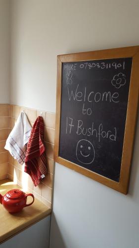 a chalkboard with a welcome to itbush food on top of a refrigerator at The Apartment Bushmills in Bushmills