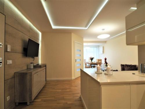 a large kitchen with a counter and a tv on the ceiling at VIP Apartamenty Stara Polana 2 in Zakopane