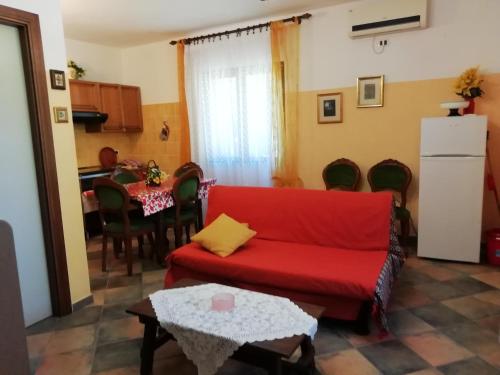 sala de estar con sofá rojo y mesa en Stanais, en Tortolì