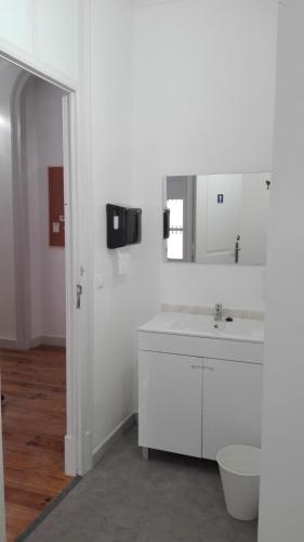 a white bathroom with a sink and a mirror at Casa Joana B&B in Cascais