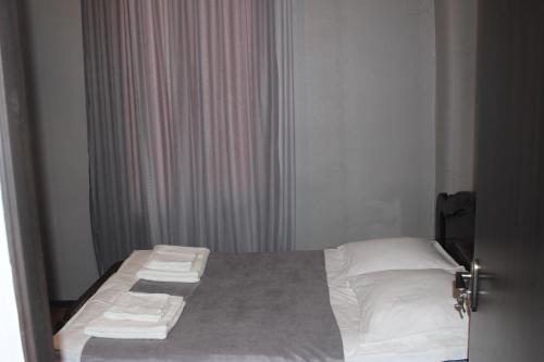 a bedroom with a bed with white sheets and pillows at Zarzma in Kutaisi