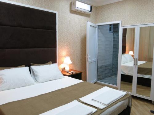 a bedroom with a large bed with a glass door at Viva hotel Gabala with outdoor pool ,Sauna and Waterfall in Gabala