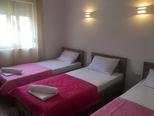 2 camas en una habitación con sábanas rosas y blancas en Helena's Sweet Home en Ulcinj