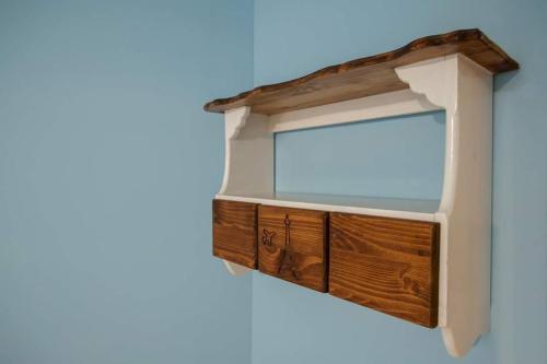 a wooden cabinet with a window on a blue wall at It's a Good Time Homestay in Guangfu
