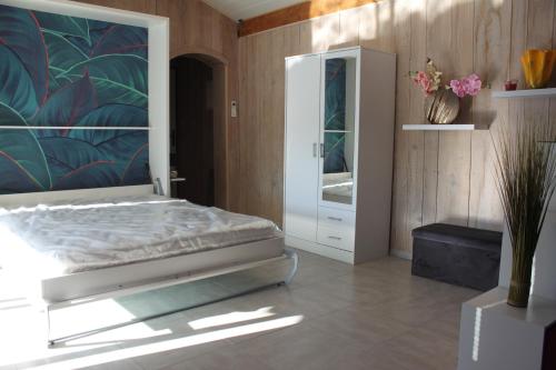 a bedroom with a bed and a dresser and a mirror at LES JARRES BLEUES in Grillon