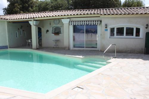 a swimming pool in front of a house at LES JARRES BLEUES in Grillon
