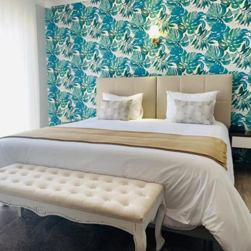 a large bed with a bench in a bedroom at Alojamento Restaurante Dom Dinis in Vila Nova de Poiares