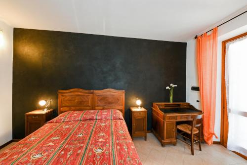 a bedroom with a large bed and a desk at Locanda Dell'Era in Dorio